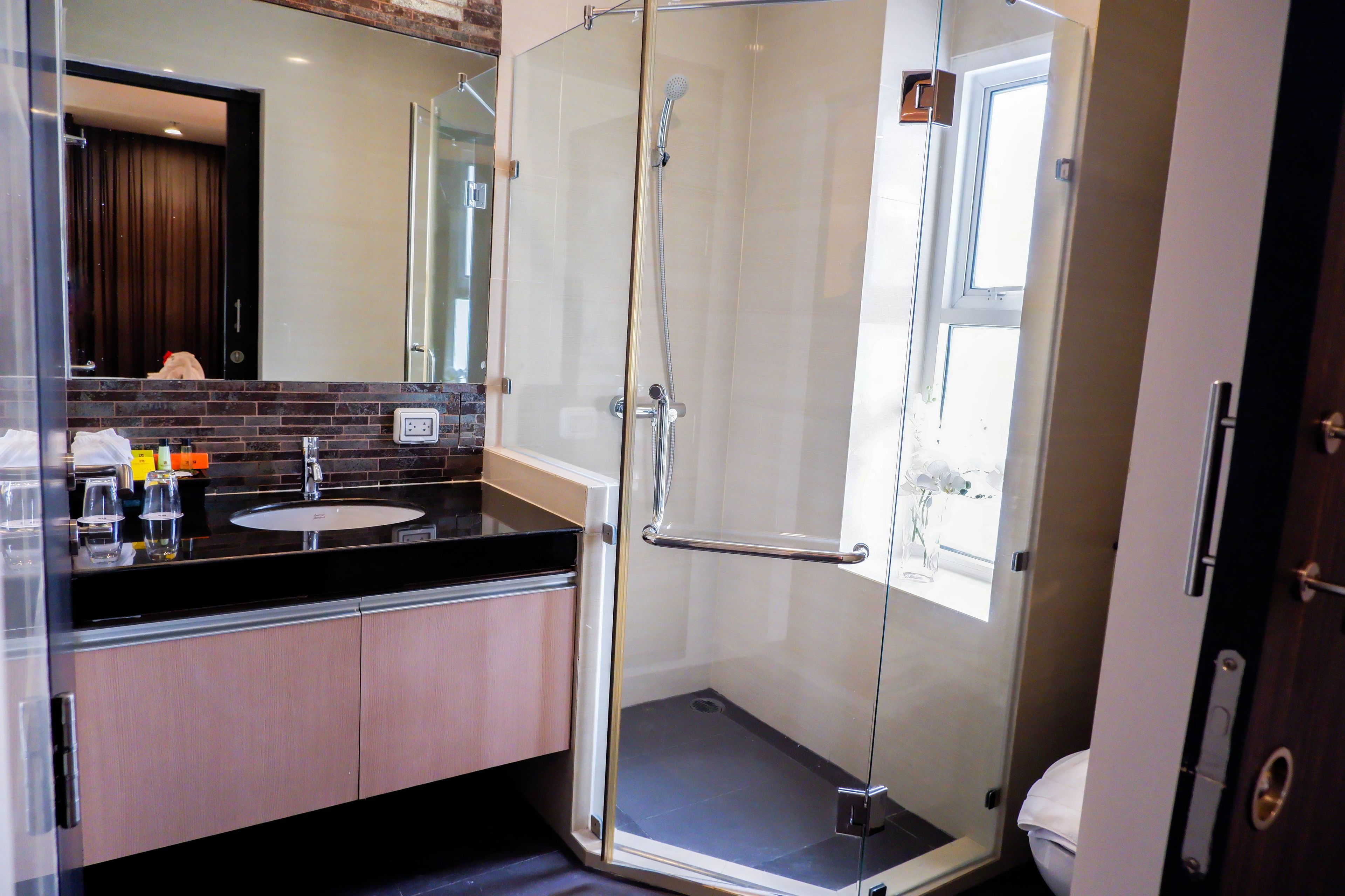 Un baño moderno con ducha de vidrio, lavamanos e inodoro.