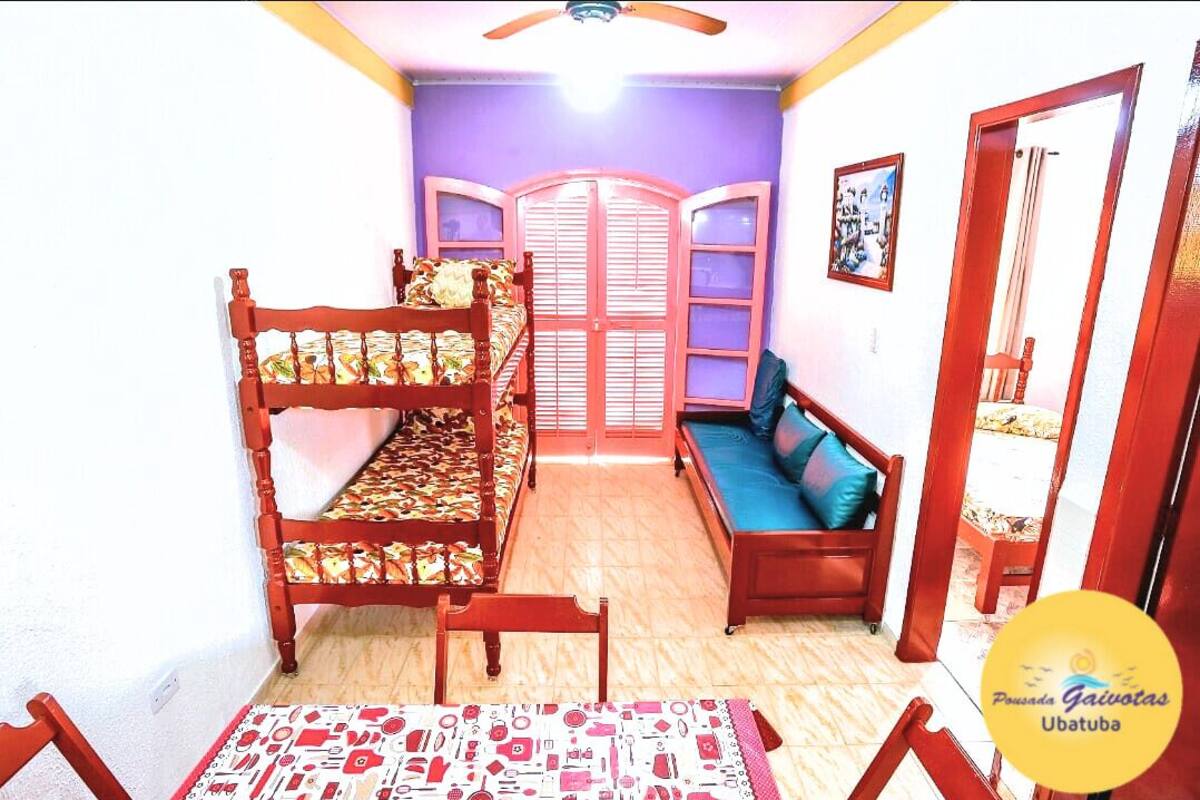 Une chambre avec un lit superposé, un canapé et une petite table.
