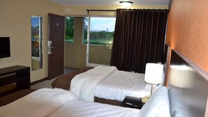 A hotel room with two beds, a desk, a TV, and a view of the outdoors. - Motel 75 Monroe (Monroe)