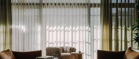 A modern living room with leather sofas, a glass coffee table, and a side table.