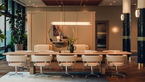 A modern conference room with a wooden table, six chairs, a vase with flowers, and a large window with plants. - PURO Poznań Stare Miasto (Poznan)