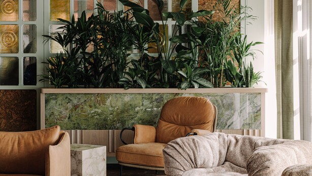 A modern living room with a fireplace, green plants, and a large window with decorative glass panels. - PURO Poznań Stare Miasto (Poznan)