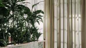 A modern interior with a marble counter, plush ottomans, and a large green plant. - PURO Poznań Stare Miasto (Poznan)