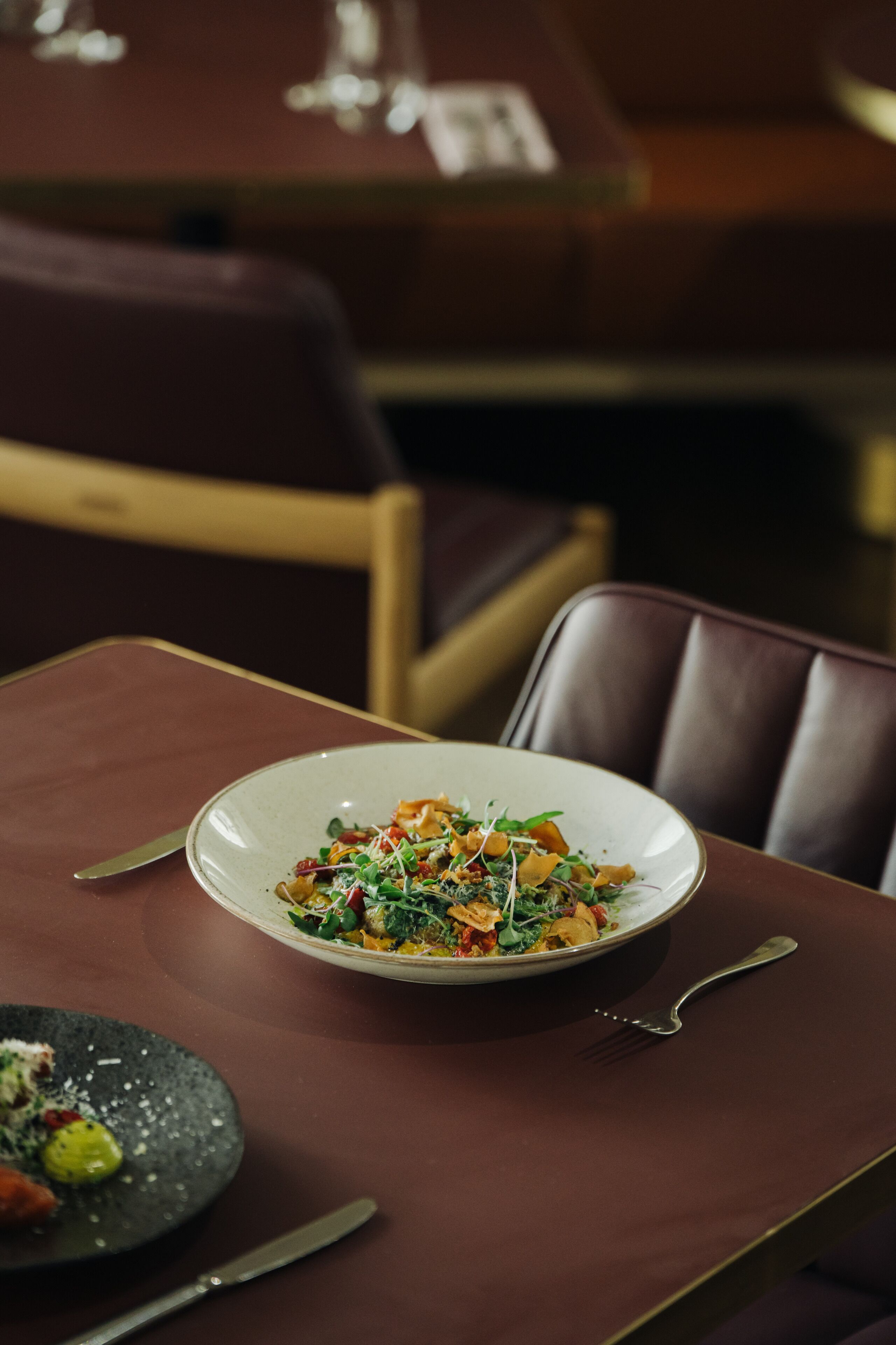 A dining table with a plate of food and cutlery.