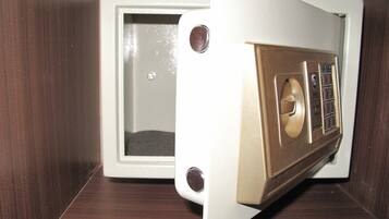 A white safe with a combination dial and a keyhole, placed on a wooden surface.