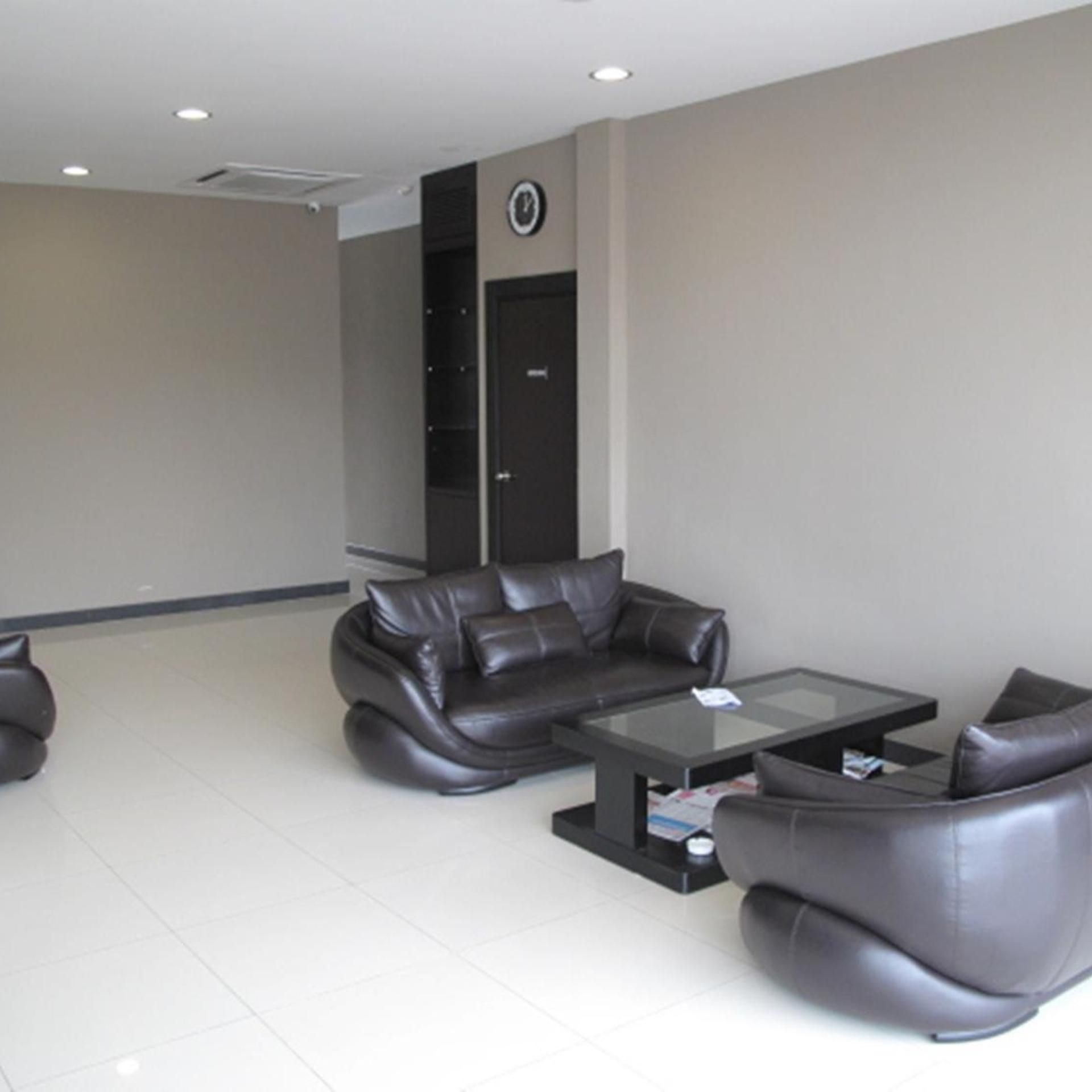A modern living room with a sofa, armchairs, and a coffee table.