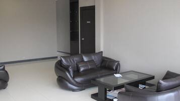 A modern living room with a sofa, armchairs, and a coffee table.