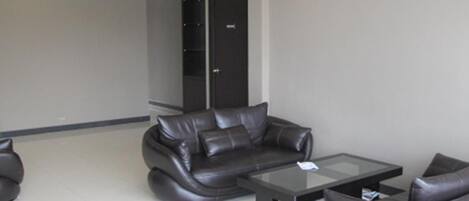 A modern living room with a sofa, armchairs, and a coffee table.