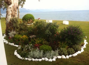 Een aangelegde tuin met diverse planten en uitzicht op zee.