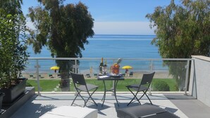 A balcony with a view of the sea, two chairs, a table, and a bottle of champagne. - Hotel Eden Park Cilento (Ispani)