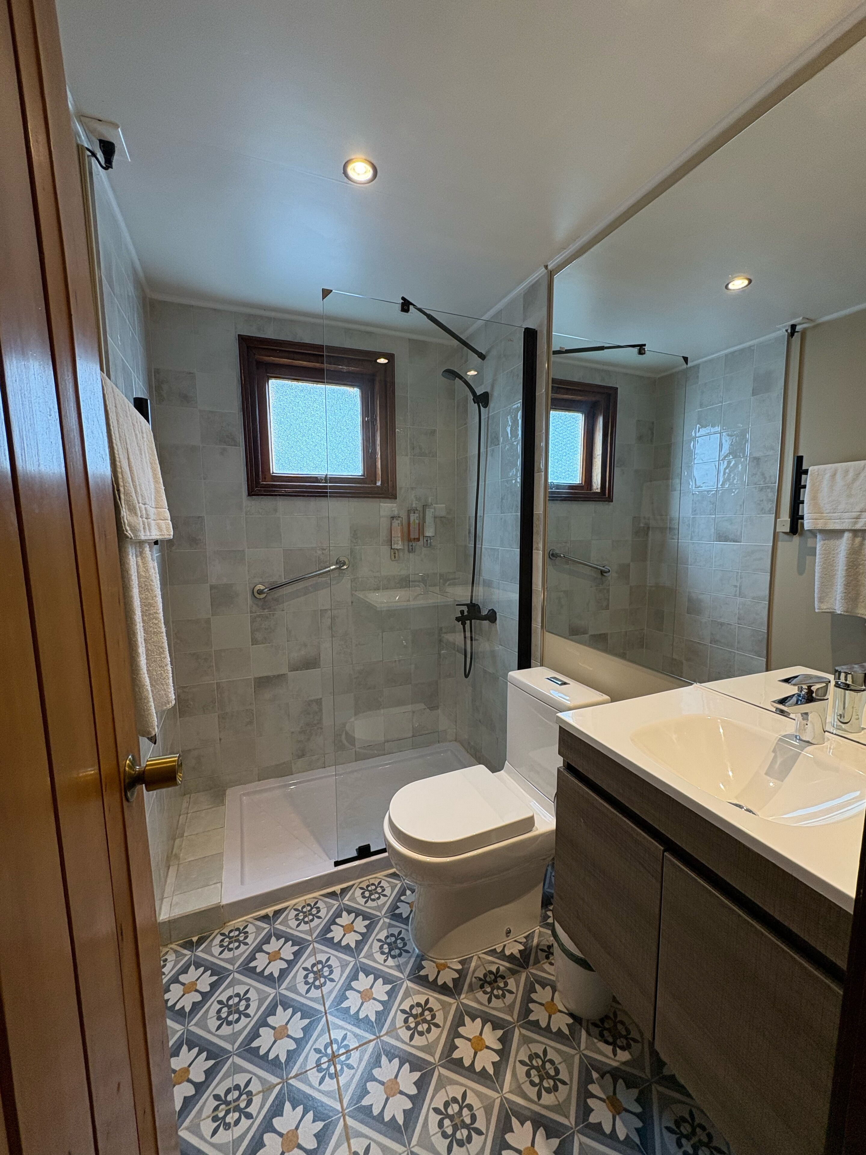 A modern bathroom with a shower, toilet, and sink.