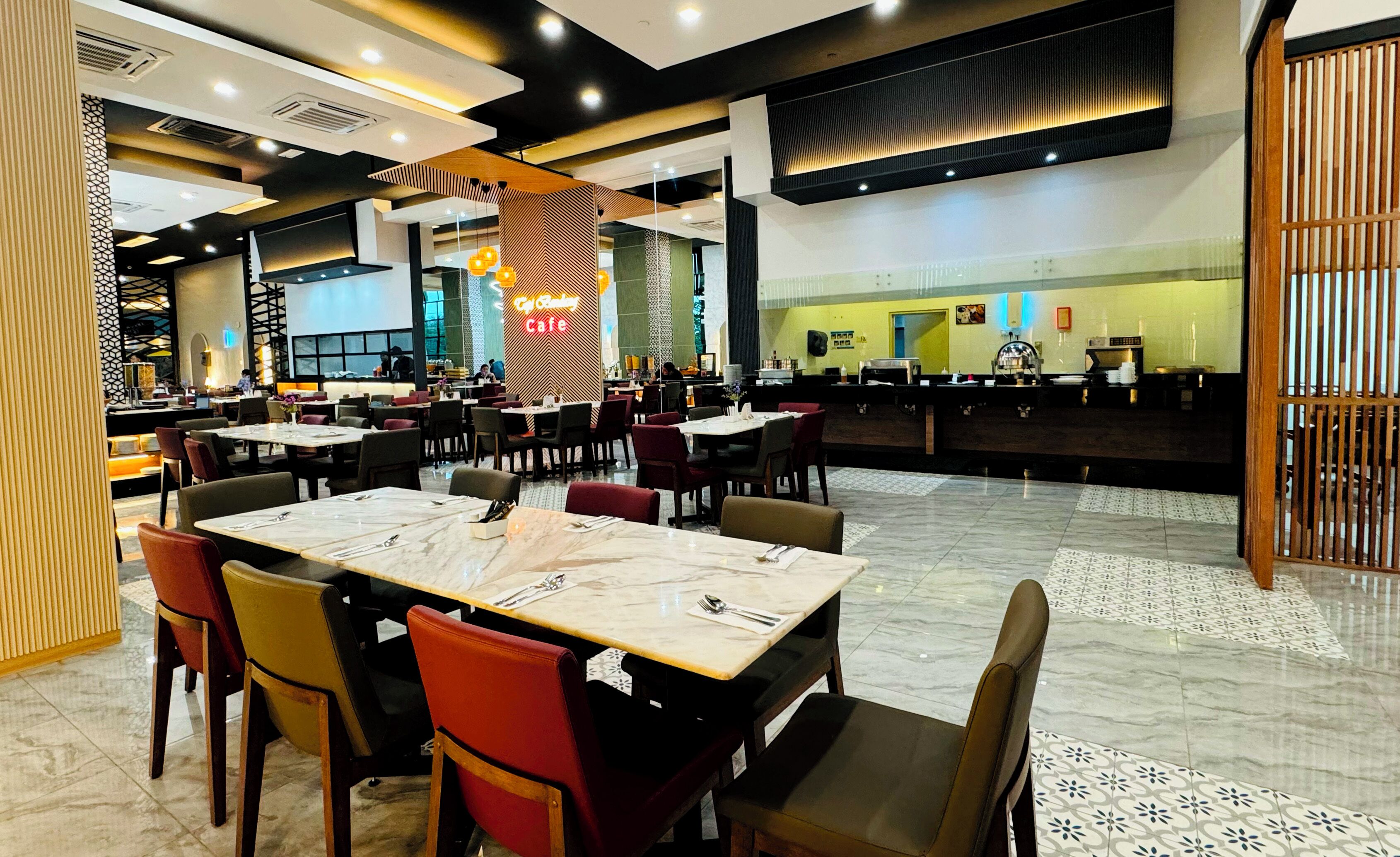 A modern restaurant with multiple dining tables and chairs, a visible counter area, and a patterned floor.