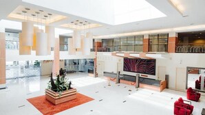 A spacious lobby with a high ceiling, a central seating area, and a large TV screen. - Raia Hotel & Convention Centre Terengganu (Kuala Terengganu)
