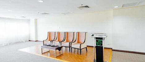 A conference room with a long table, four chairs, and a podium.