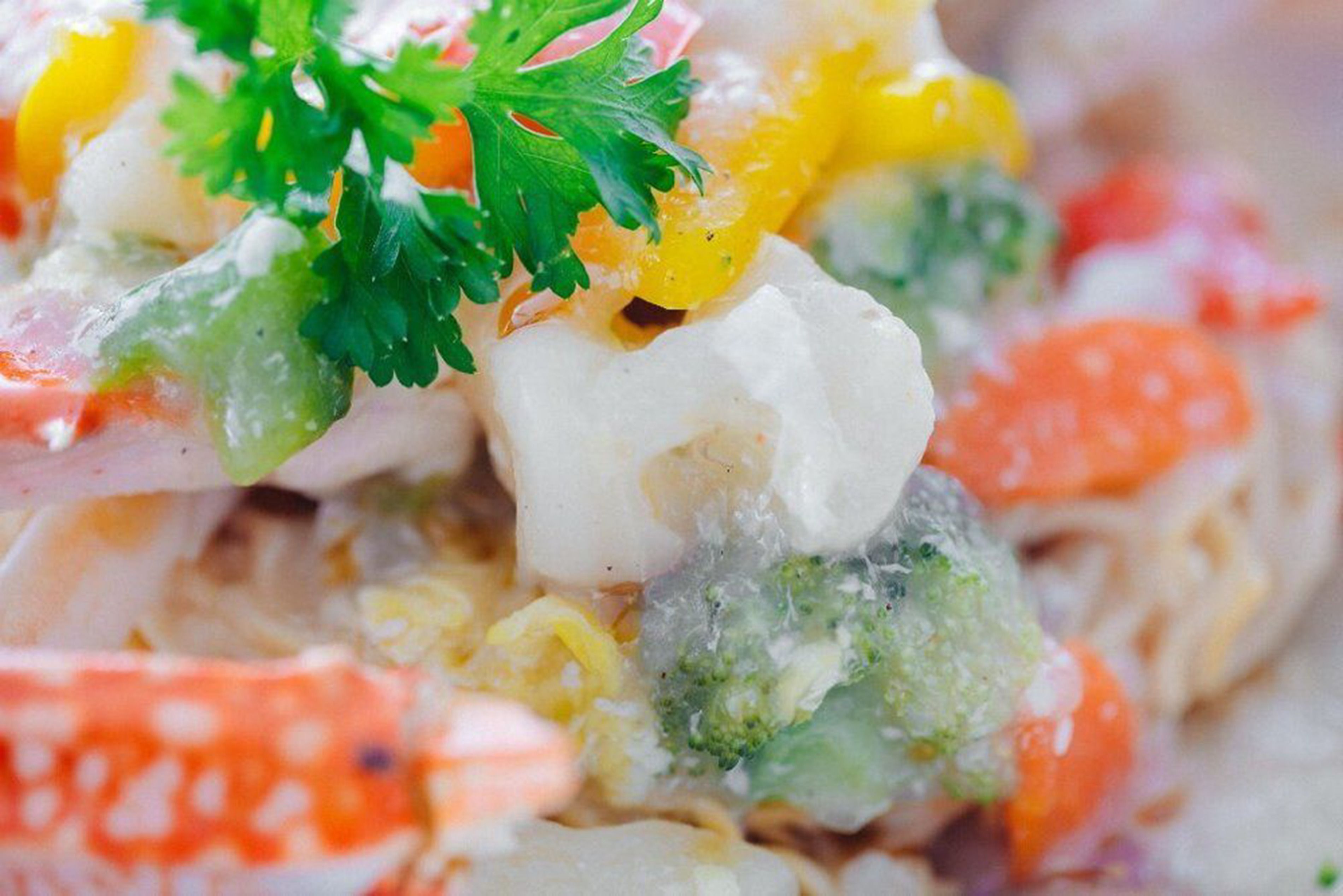 A close-up of a seafood salad with various ingredients like shrimp, crab, and vegetables.