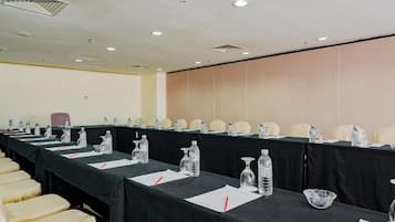 A conference room with a long table, chairs, water bottles, and papers.