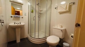 Une salle de bain avec une douche à parois de verre, un lavabo et des toilettes.