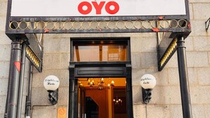 L’entrée d’un hôtel, avec une enseigne indiquant « OYO » et deux autres enseignes indiquant « Highland Lodge ».