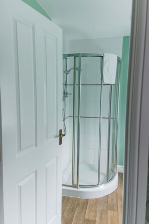 A glass-enclosed shower with a white towel hanging on the door. - Northover Manor Hotel (Yeovil)