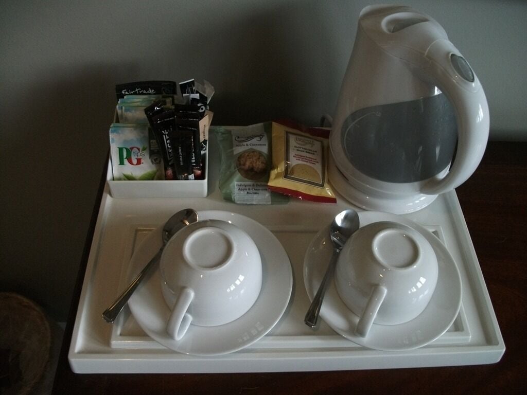 A tray with a white teapot, two white cups, a spoon, and a box of PG Tips tea bags.