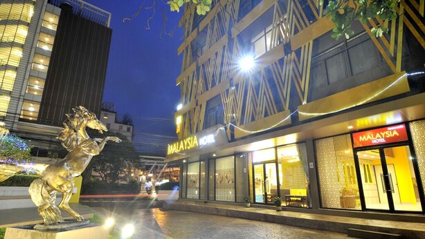 Een hotel in Maleisië met een moderne gevel, grote ramen en een goed verlichte entree.