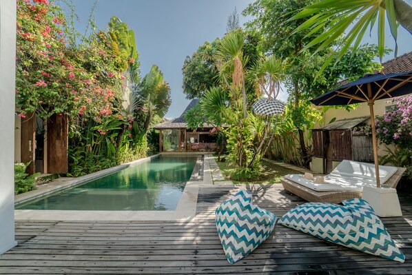 室外游泳池，提供泳池遮陽傘和日光浴躺椅