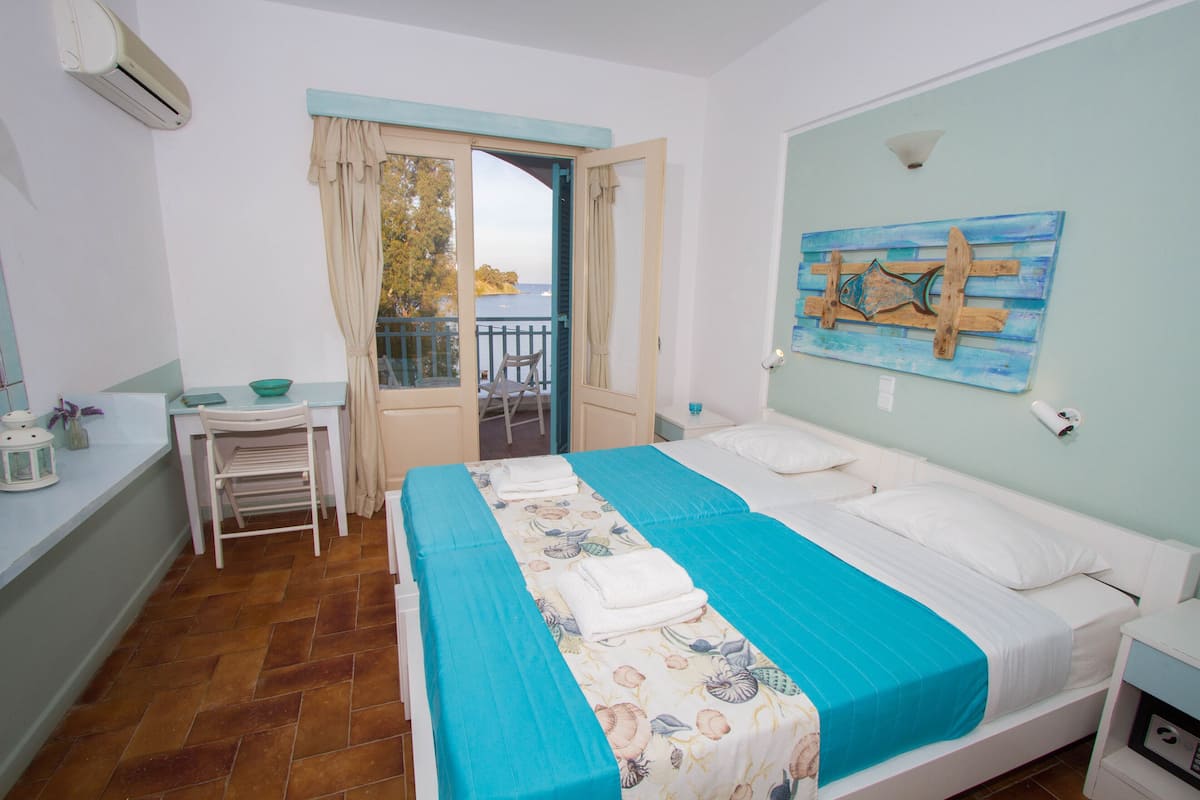 A bedroom with a bed, a desk, a chair, a window with curtains, and a painting on the wall.