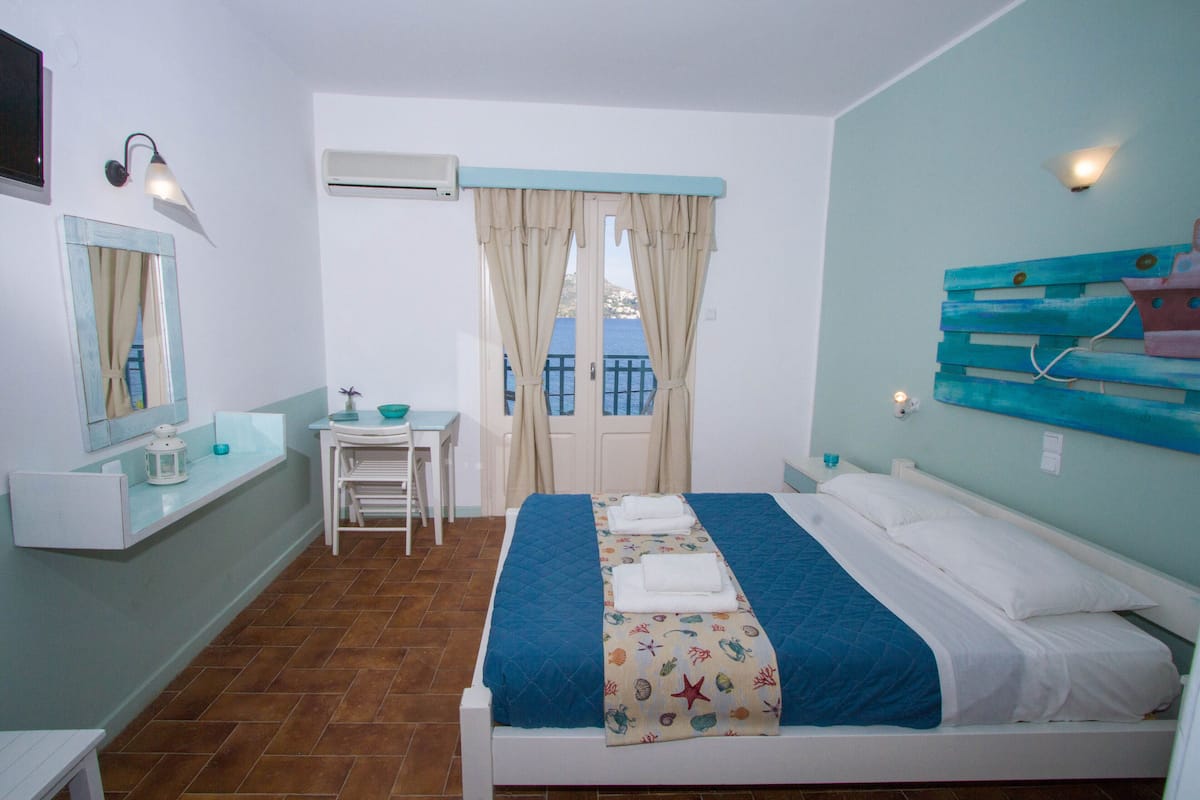 A bedroom with a bed, a desk, a chair, and a window with curtains.