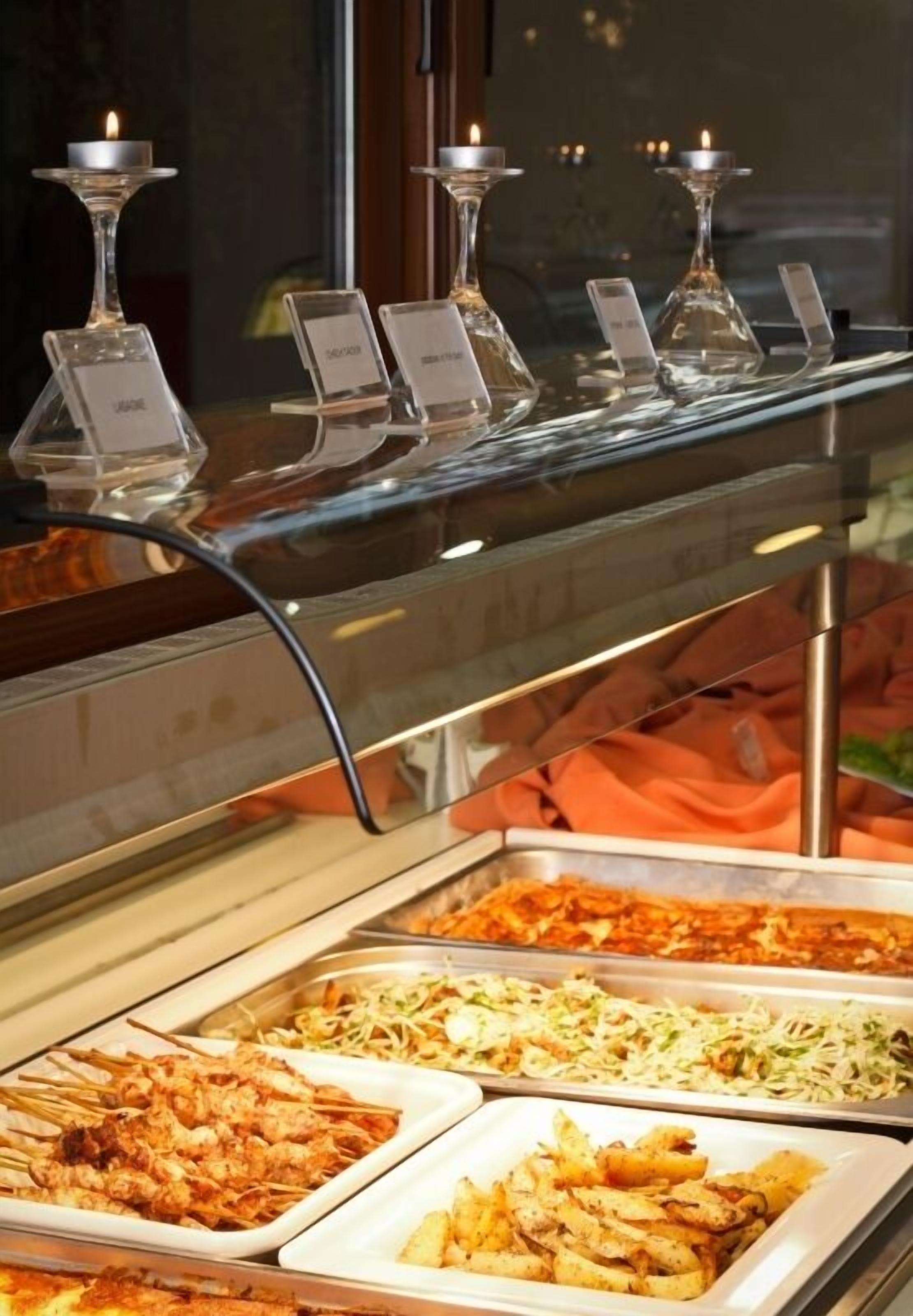 A buffet with various dishes and candle holders.