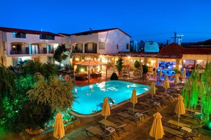 Una piscina al aire libre de temporada, sombrillas