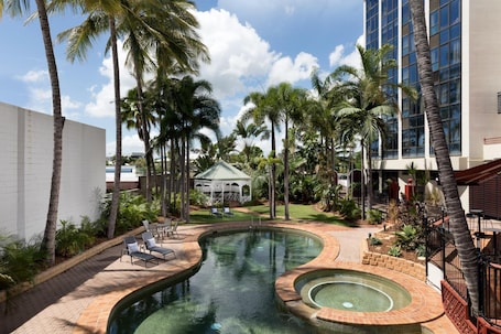 Una piscina al aire libre, sillones reclinables de piscina