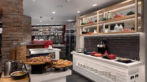 A modern kitchen with a buffet setup, including a variety of food items and beverages. - Townsville Southbank Apartments (South Townsville)