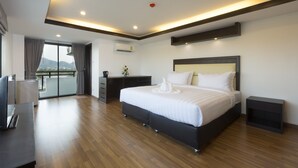 Quarto de hotel moderno com uma cama grande, uma escrivaninha e varanda com vista.