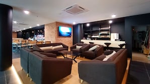 A modern lounge area with sofas and a bar. - Raia Inn Penang (George Town)