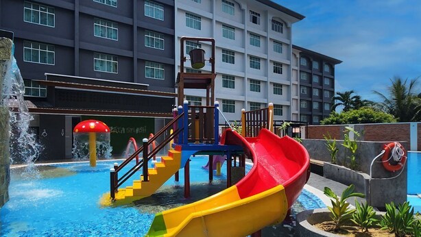 A water park with slides and a pool, surrounded by a building with multiple windows. - Raia Inn Penang (George Town)