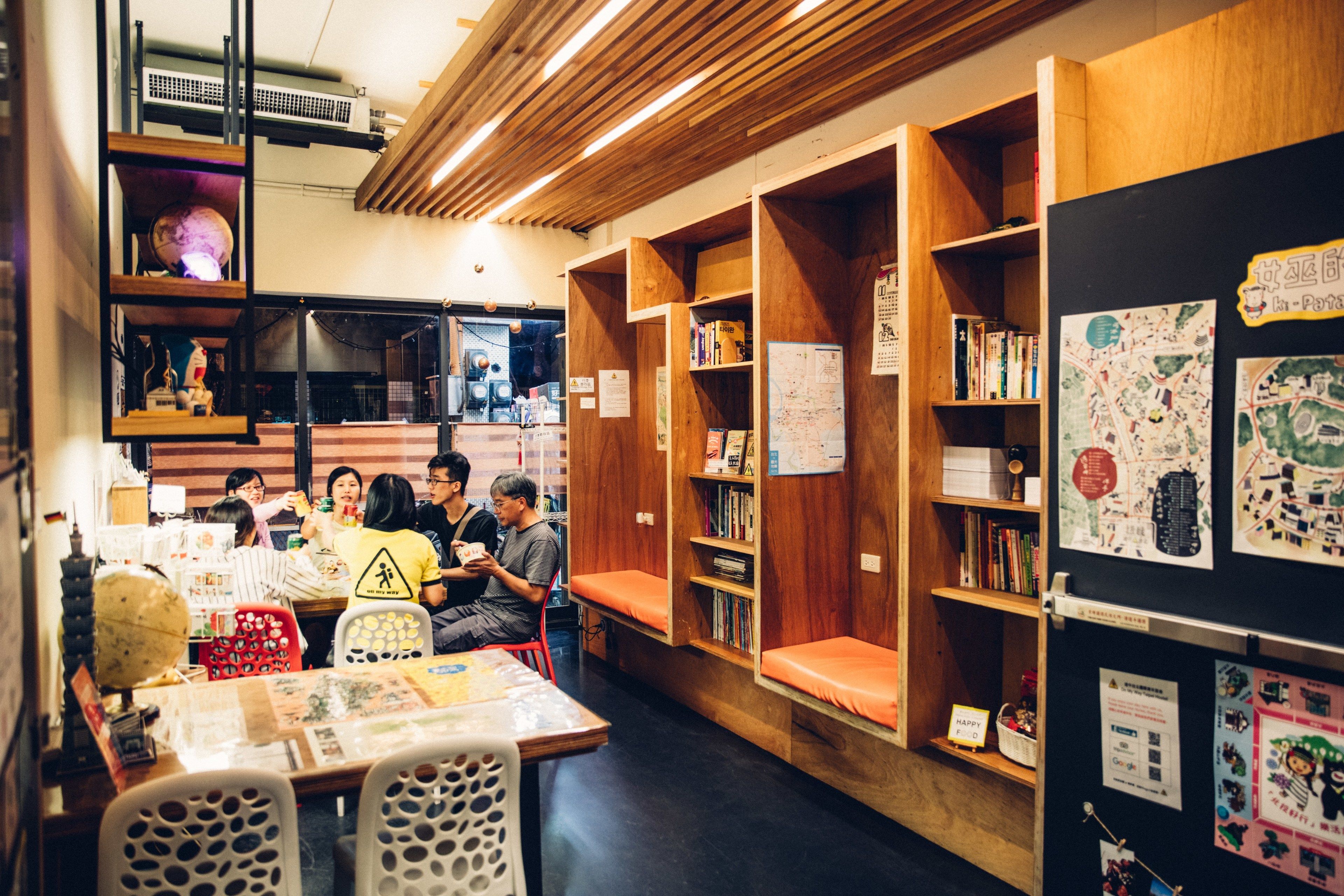 A library with wooden bookshelves, tables, and chairs.