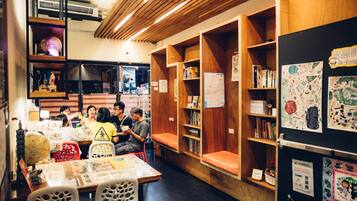 A library with wooden bookshelves, tables, and chairs.