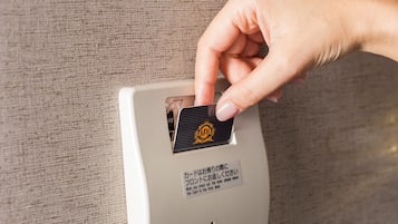 A hand inserting a card into a card reader on a white machine.