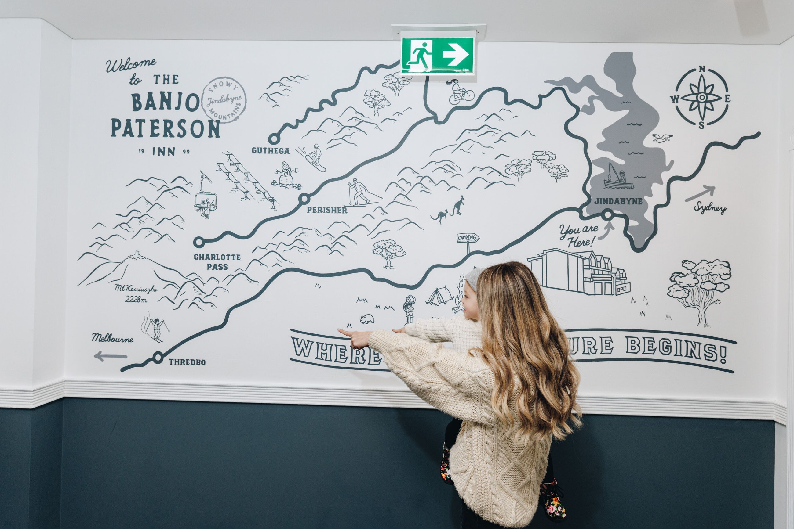 Mapa de pared con una brújula, mostrando lugares como 'Banjo Paterson' y 'Jindabyne'.