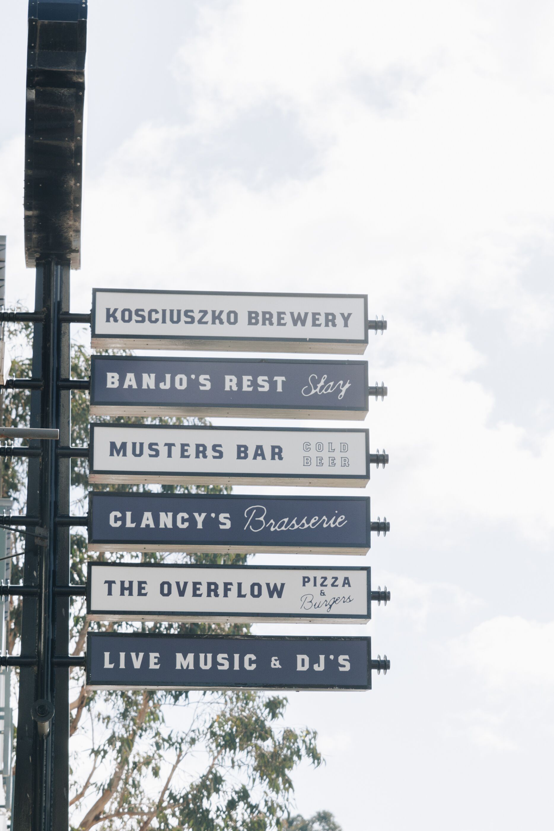 Skilt med flere navne på virksomheder, heriblandt et bryggeri, en bar og et sted med livemusik og DJ's.