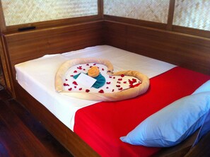 A bed with a heart-shaped pillow, a red blanket, and a blue pillow. - Sukkasem Homestay (Hua Hin)