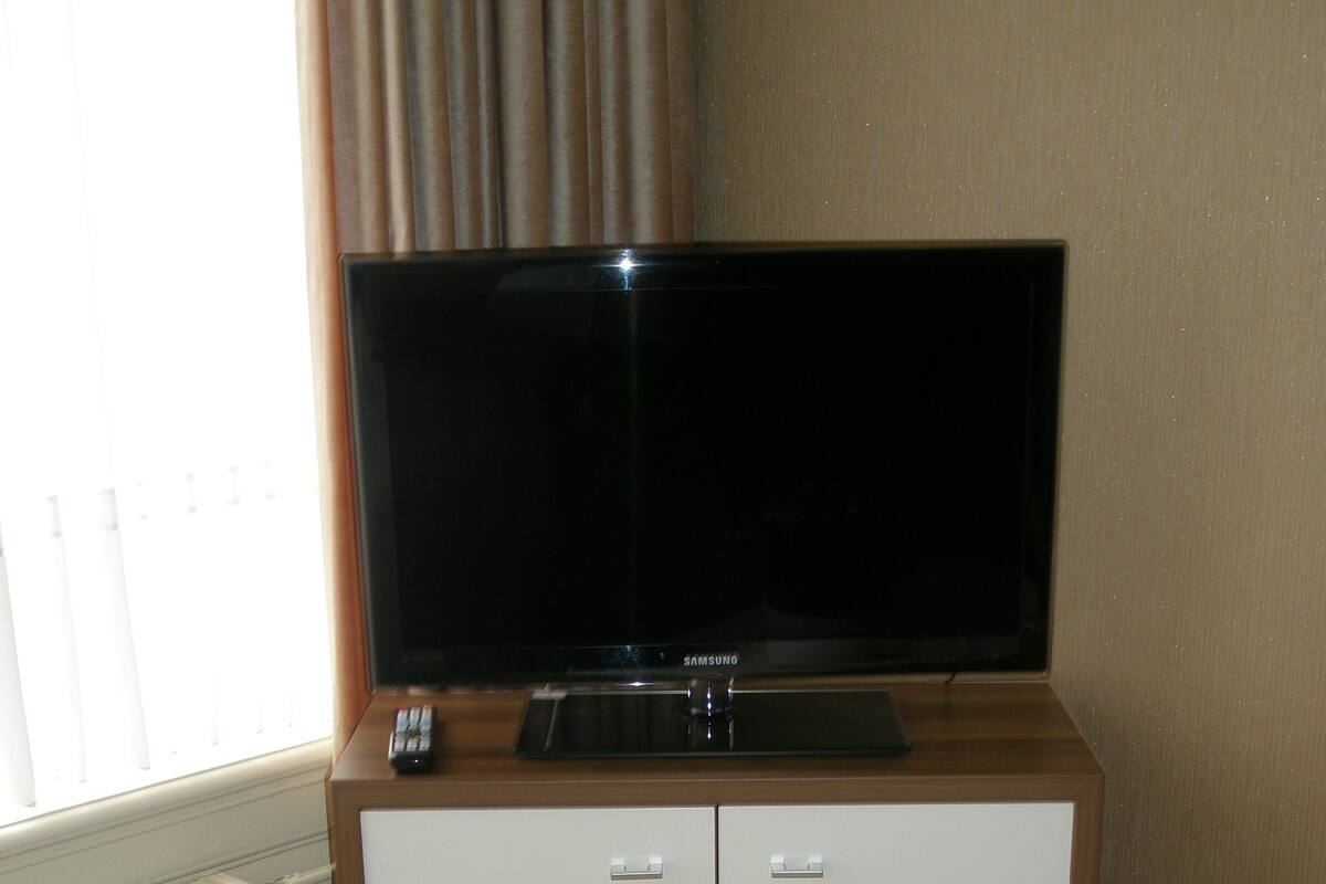 Un televisor sobre un mueble en una habitación de hotel.