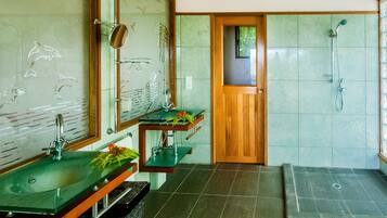 Een badkamer met een groene wastafel, een houten deur en een douchehoek.