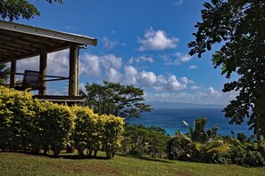 Uma área de estar coberta ao ar livre, com vista para o oceano.
