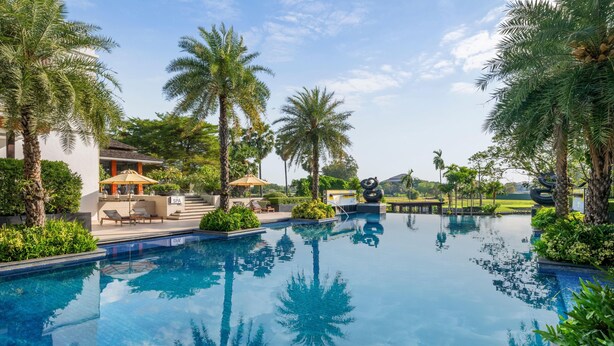 A swimming pool surrounded by palm trees and a spa area. - Hilton Bangkok Suvarnabhumi Golf Resort & Spa (Bang Phli)
