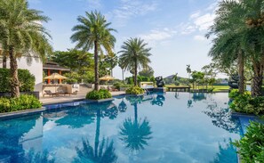 A swimming pool surrounded by palm trees and a spa area. - Hilton Bangkok Suvarnabhumi Golf Resort & Spa (Bang Phli)