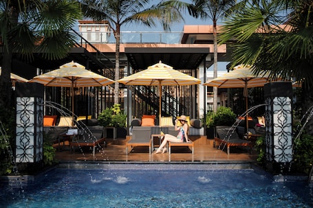 Una piscina al aire libre, camas de piscina gratis, sombrillas