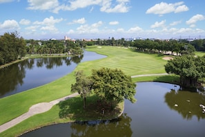 A golf course with a pond, trees, and a clear sky. - Hilton Bangkok Suvarnabhumi Golf Resort & Spa (Bang Phli)