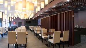A modern restaurant with high ceilings, pendant lighting, and a long counter with chairs. - Slavyanskaya Hotel (Minsk)