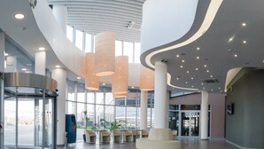 A modern lobby with a revolving door, seating area, and large windows. - Slavyanskaya Hotel (Minsk)